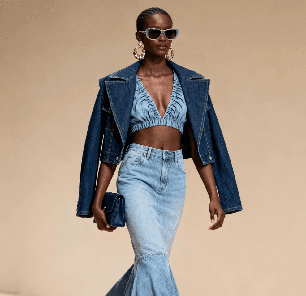 Model in a denim bralette and wide-leg jeans with a blazer