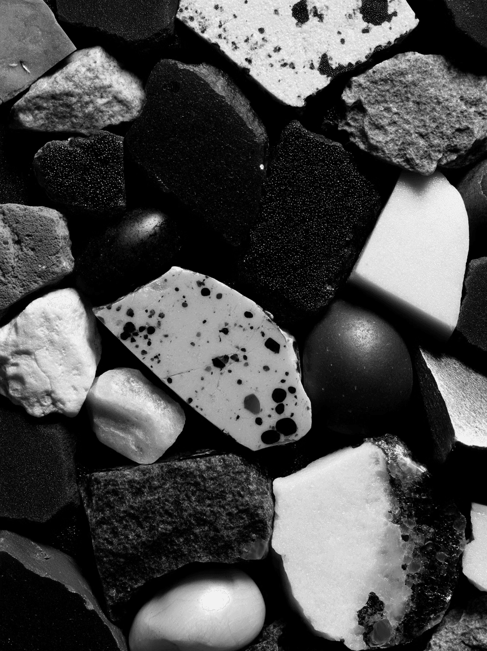 Close-up of dark rocks and pebbles with scattered light